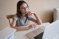 Pretty teenager girl doing homework sitting behind the table at home Royalty Free Stock Photo