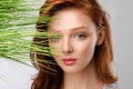 Girl With Loose Red Hair Posing With Grass, Gray Background