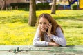 Pretty teenager girl talking by mobile cellpfone smartphone at the summer park Royalty Free Stock Photo