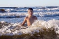 Pretty teenager playing in foamy waves of the Baltic Sea Royalty Free Stock Photo