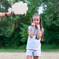 Pretty thinking little girl puts on a happy face, summer nature outdoor with cloud of thoughts like in comic book. Kid`s Royalty Free Stock Photo