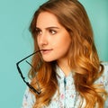 Pretty thoughtful girl wearing glasses over blue background Royalty Free Stock Photo