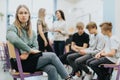 Pretty teenage girl sits on the side of a group during extracurricular activities at school