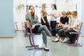 Thoughtful teenage girl sits on the side of a group during extracurricular activities at school