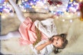 Pretty toddler girl liying near decorating Christmas interior