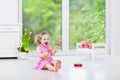 Pretty toddler girl playing maracas in white room
