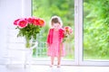 Pretty toddler girl playing with peony flowers Royalty Free Stock Photo