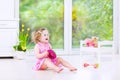 Pretty toddler girl playing tambourine in white room Royalty Free Stock Photo