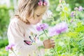 Pretty Toddler girl smelling a flower