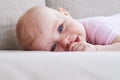 Pretty toddler lying on sofa and sucking thumb Royalty Free Stock Photo