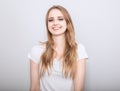 Pretty toothy laughing young woman with fair blond long hair in casual dress. Studio shot of good looking beautiful woman isolated Royalty Free Stock Photo