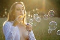 Pretty topless woman on a meadow blowing soap bubbles on a summer evening Royalty Free Stock Photo