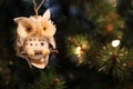 Pretty traditional owl decoration hanging on a Christmas tree wi