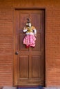 Pretty traditional style Burmese string puppet decoration on copper colored door Royalty Free Stock Photo