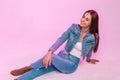 Pretty trendy happy young woman with lovely smile in stylish youth blue jeans clothes resting and positive smiling near vintage Royalty Free Stock Photo