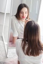 Pretty tween girl rouge lips holding red lipstick looking at big mirror Royalty Free Stock Photo