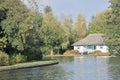 Pretty UK riverside cottage with large river Royalty Free Stock Photo