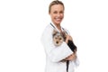 Pretty vet holding yorkshire terrier puppy smiling at camera Royalty Free Stock Photo