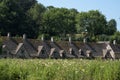 Pretty village of Bibury in the Cotswolds UK, with water meadow in the foreground and Arlington Row cottages at back