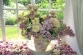 China jug with mixed garden flowers on windowsill