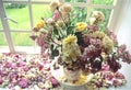 China jug with mixed garden flowers on windowsill