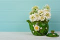 Pretty White Spring Flowers in a Vintage Asian Pot on Wood Table with Teal Boards Background in shabby chic style.  It`s a Horizo Royalty Free Stock Photo