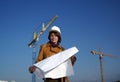 Pretty woman architect with blueprints and cranes Royalty Free Stock Photo