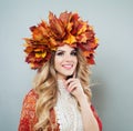 Pretty woman in autumn leaves crown. Happy model with makeup and curly hair, autumn portrait