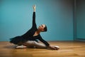 Pretty woman ballerina in tutu and pointe in black swimsuit posing in studio on blue background Royalty Free Stock Photo