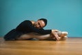 Pretty woman ballerina in tutu and pointe in black swimsuit posing in studio on blue background Royalty Free Stock Photo