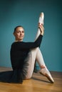 Pretty woman ballerina in tutu and pointe in black swimsuit posing in studio on blue background Royalty Free Stock Photo