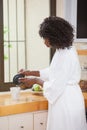 Pretty woman in bathrobe pouring coffee Royalty Free Stock Photo