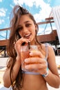 Pretty woman in bikini drinking cocktail at pool party. Royalty Free Stock Photo