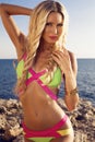 Pretty woman with blond hair in bright bikini posing on beach Royalty Free Stock Photo