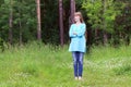 Pretty woman in blue stands in forest