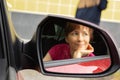 Pretty woman in car window. Smiling girl in car mirror. Travel concept. Joyful journey concept. City traffic concept.