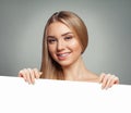Pretty woman with clear skin holding empty white card singboard Royalty Free Stock Photo