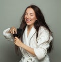 Pretty woman combing her tangled hair on white background, hair care concept Royalty Free Stock Photo