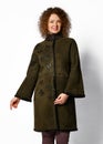 Pretty woman with curly red hair poses in brown sheepskin coat with karakul collar and cuffs and with butterfly embossed
