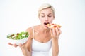 Pretty woman deciding eating pizza rather the salad Royalty Free Stock Photo