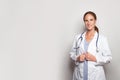 Pretty woman doctor hospital worker looking at camera and smiling against grey studio wall banner background Royalty Free Stock Photo