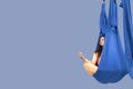 Pretty woman doing yoga stretching exercises in the gym, meditating in lotus position in aerial yoga hammocks, banner Royalty Free Stock Photo