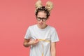 Girl with dreads in a white shirt and glasses looking is upset measuring her boobs Royalty Free Stock Photo