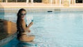 The pretty woman drinking blue cocktail alcohol liquor and sit at the bar. Cocktail bar in the swimming pool. Portrait Royalty Free Stock Photo