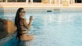 The pretty woman drinking blue cocktail alcohol liquor and sit at the bar. Cocktail bar in the swimming pool. Portrait Royalty Free Stock Photo