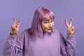 Pretty woman with dyed purple hair showing with hands and two fingers air quotes gesture, bend fingers isolated over Royalty Free Stock Photo