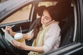 Pretty woman eating food and driving in her car.