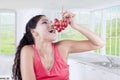 Pretty woman eating grapes in kitchen Royalty Free Stock Photo