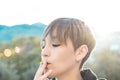 Pretty woman with a flower in her mouth. Girl smoking a flower, health concept Royalty Free Stock Photo