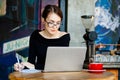 Pretty woman in glasses works on a laptop, uses a smartphone, a freelancer, a computer, financial analyst, a sales manager. Royalty Free Stock Photo